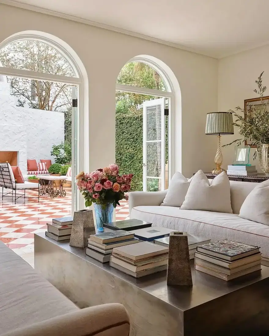 Cream room with arched doors open to a checkered terrace