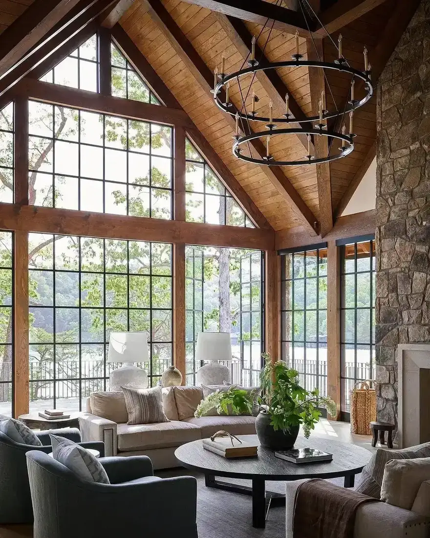 Cabin sitting room with uneven reclaimed beams and soft daylight from tall windows