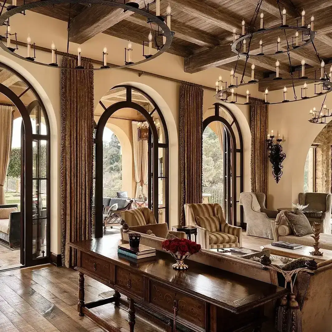 Elegant rustic sitting room with arched windows, reclaimed beams and warm lamplight
