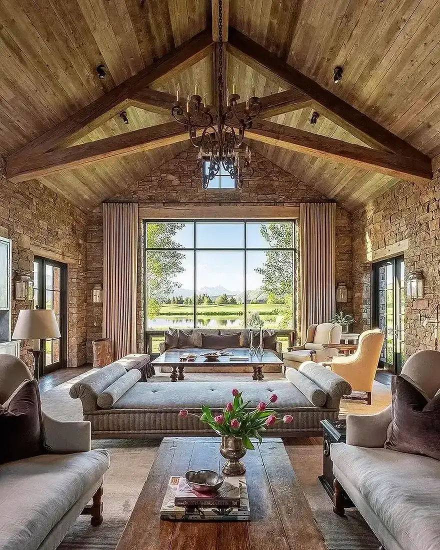 Vaulted white sitting room with layered textiles under a rhythmic beamed ceiling