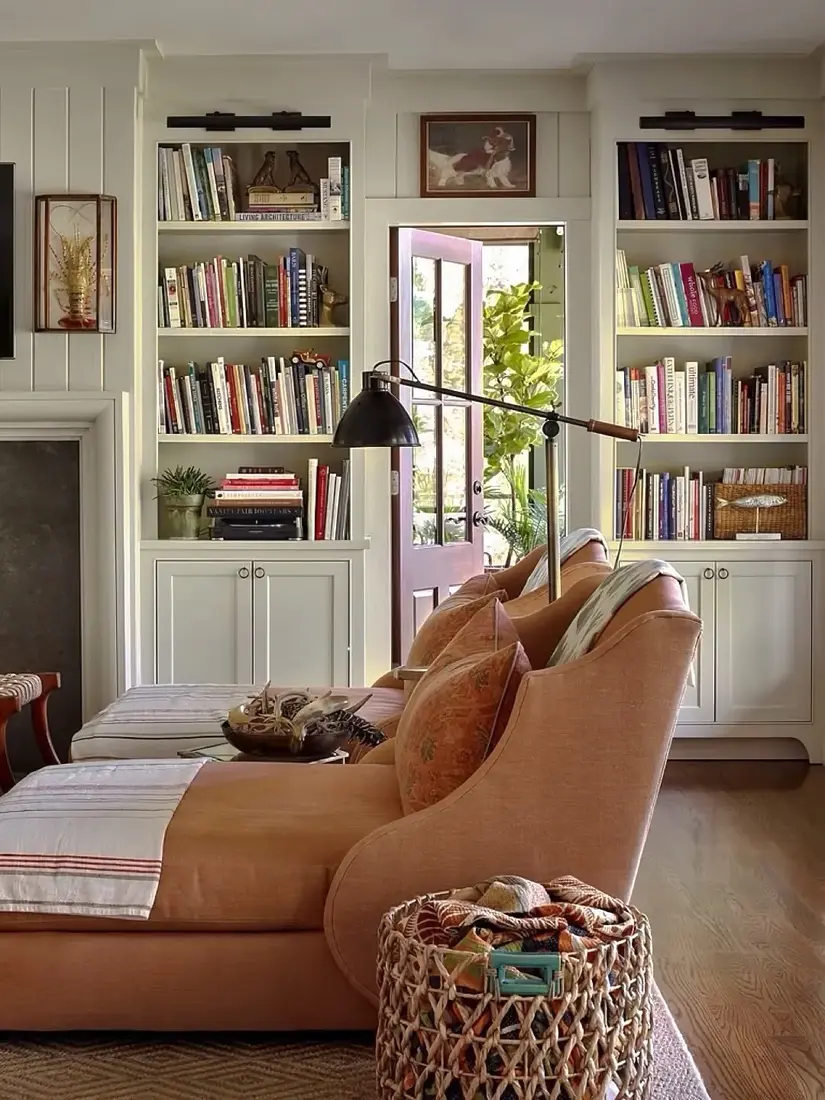 Peach sitting room with shallow shelves, soft daylight and objects given air