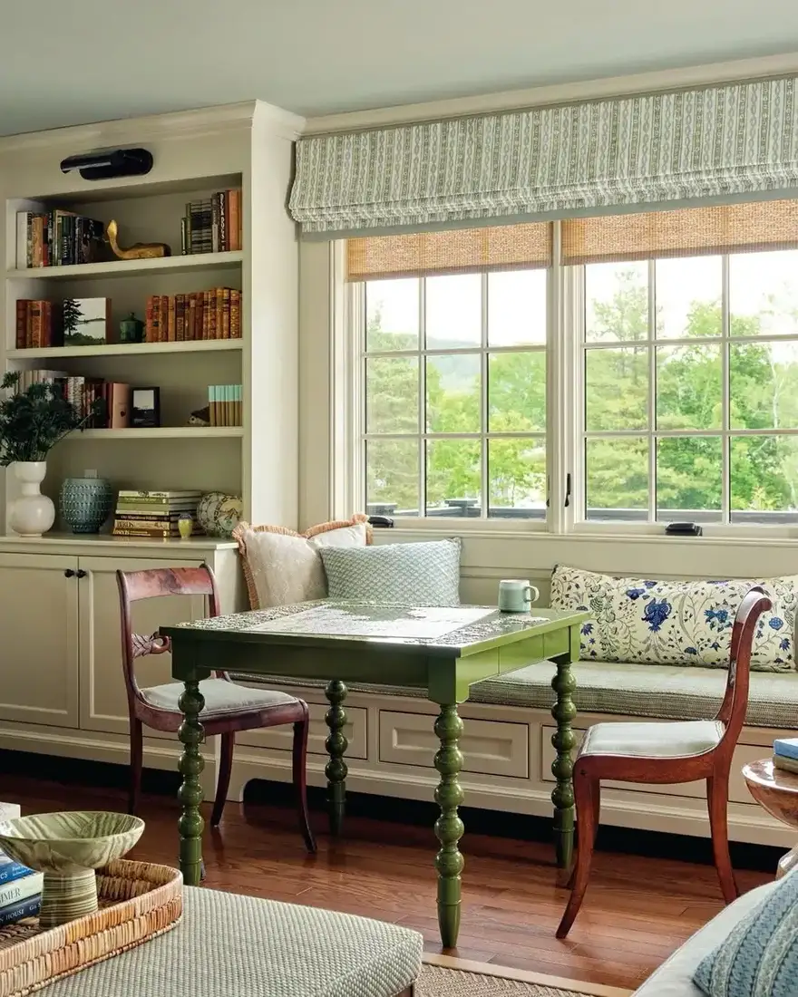 Window seat with bookshelves alongside and a green side table within reach